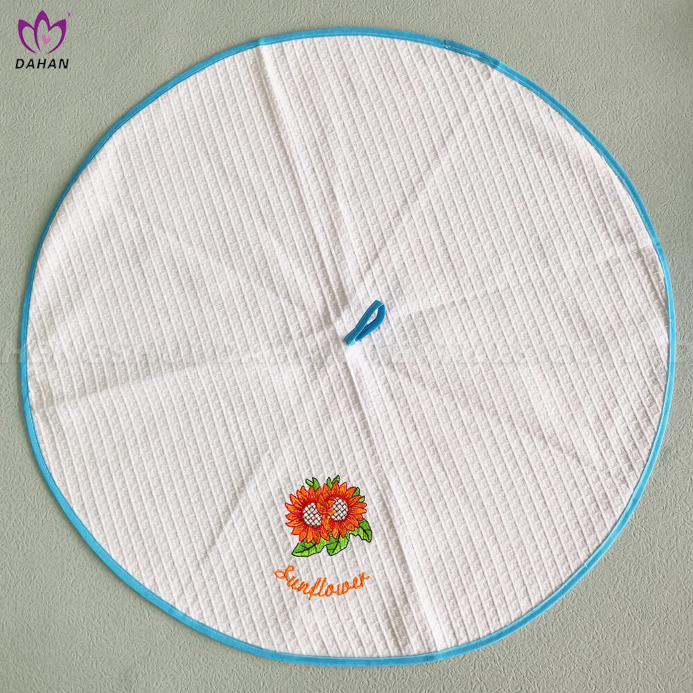 EM9 Embroidered round tea towel.